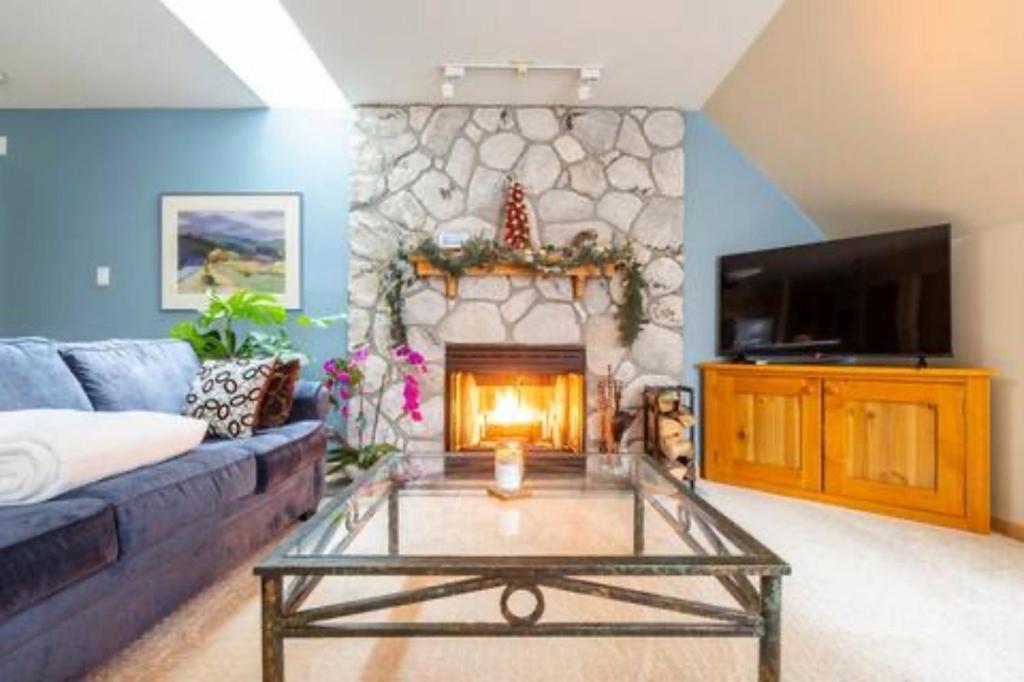a living room with a couch and a fireplace at 31GlenEagle Whistler in Whistler