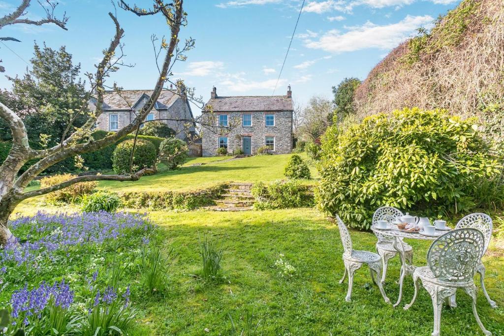 a garden with chairs and a table in front of a house at 4 Bed in St. Mawgan oc-p00610 in Saint Mawgan