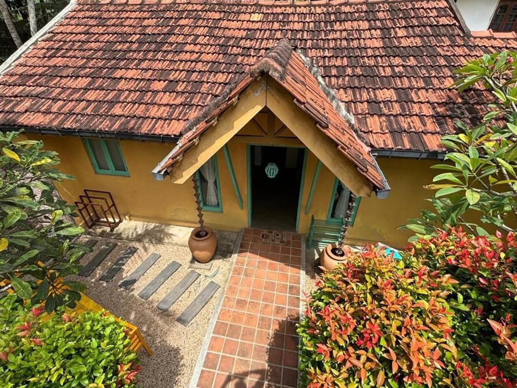 a small yellow house with a tile roof at Casa Meraki in Dickwella