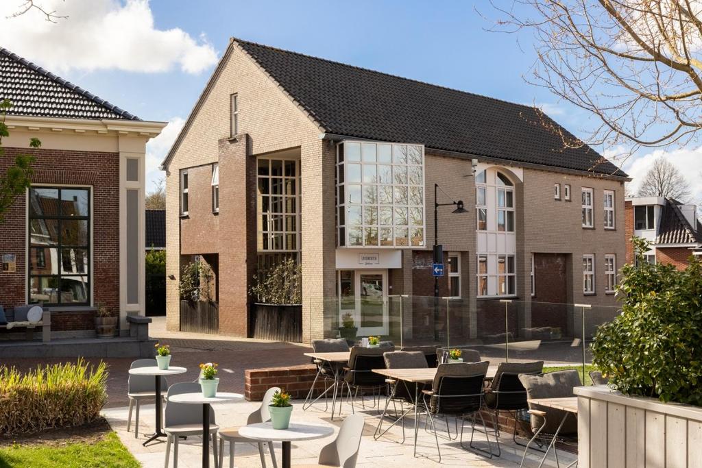 a group of tables and chairs in front of a building at Logementen Dokkum in Dokkum
