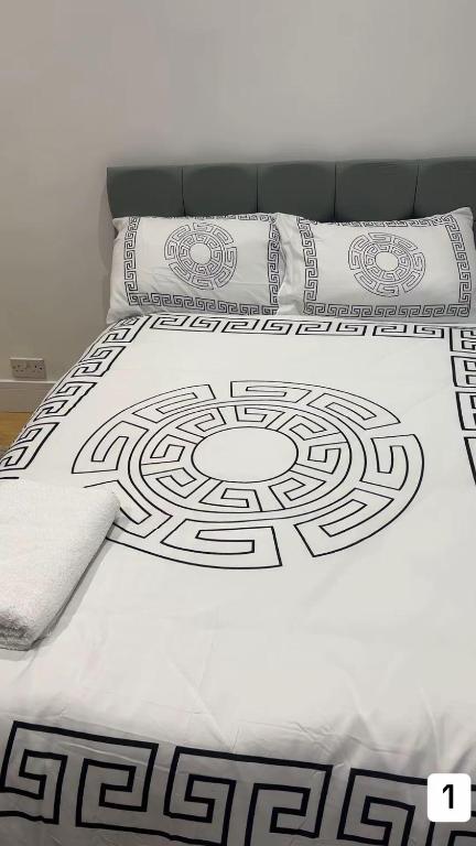 a bed with a black and white comforter on it at PLUS Properties Oxford 1 in Stoke on Trent