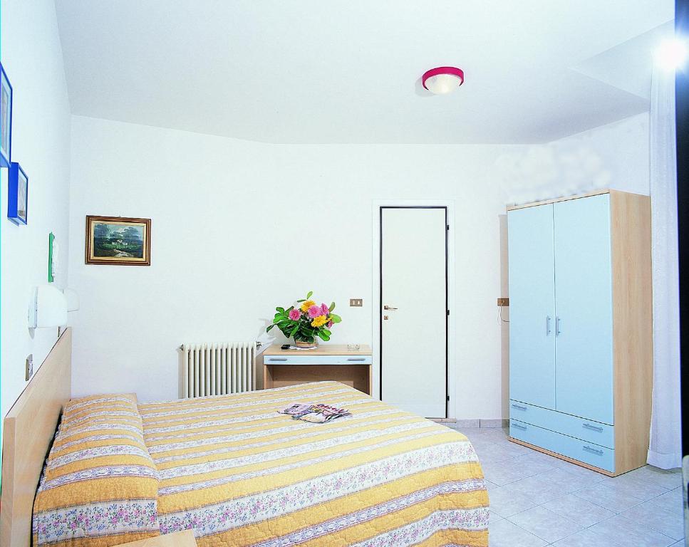 リミニにあるHotel Acquazzurraの白いベッドルーム(ベッド1台、鏡付)