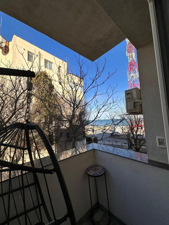 a balcony with a chair and a view of a building at Matei's Apartment by the Sea in Constanţa
