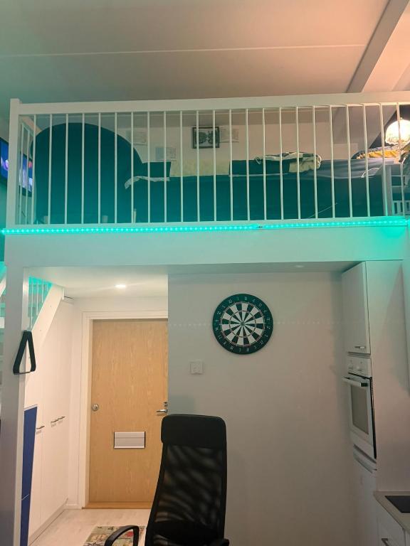 a room with a staircase with a clock and a bed at Urban Pair Luxe Suites in Vantaa