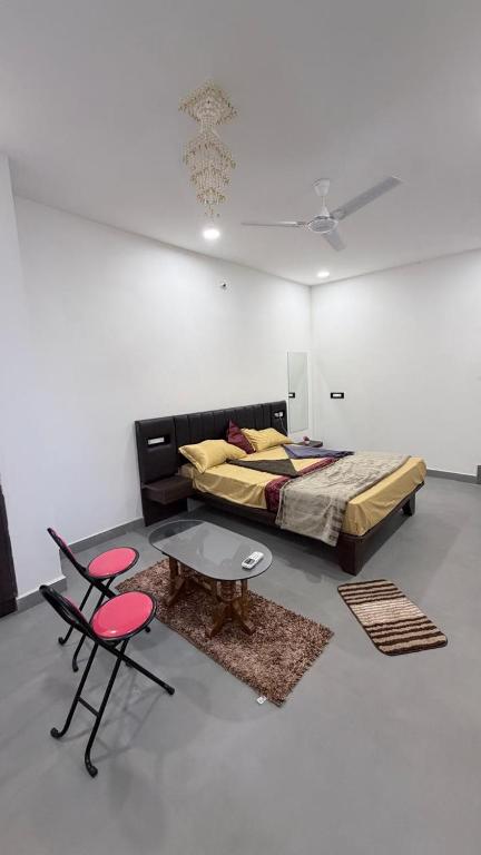 a bedroom with a bed and a table and chairs at rajapalace in Zahirābād