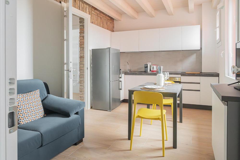 a kitchen with a table and a chair and a couch at LaVero Maison in Castelfranco Emilia