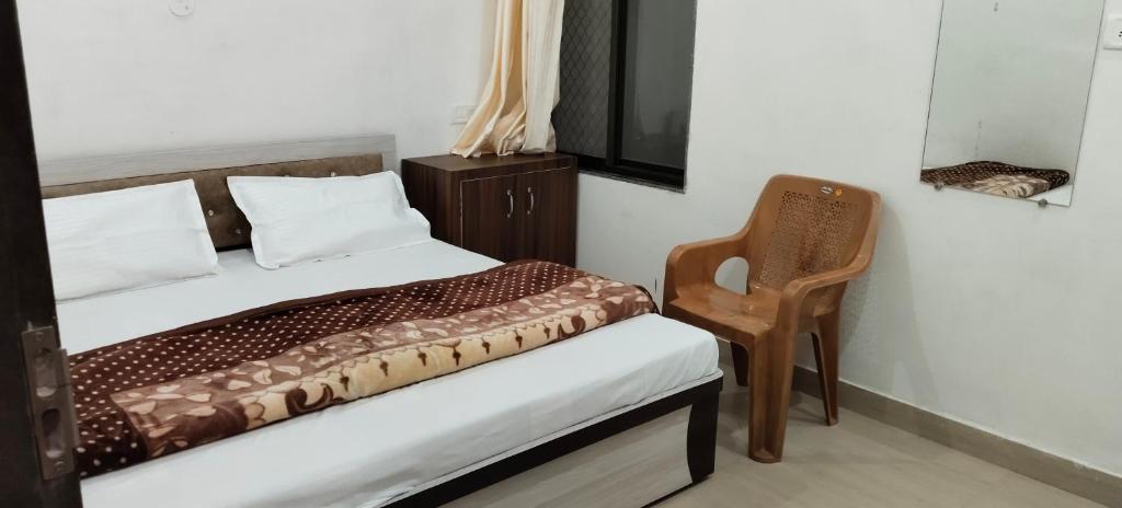 a small bedroom with a bed and a chair at Hotel Manasvi in Khātu