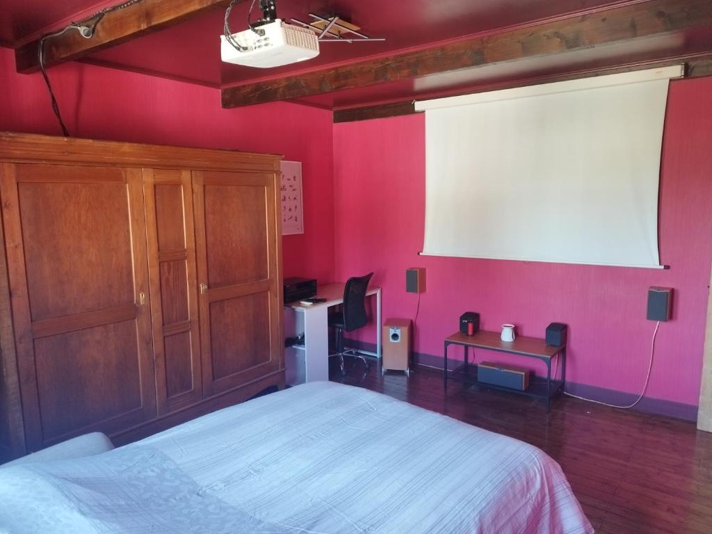 a bedroom with a white bed and a pink wall at Chambre, comme au cinéma in Givet
