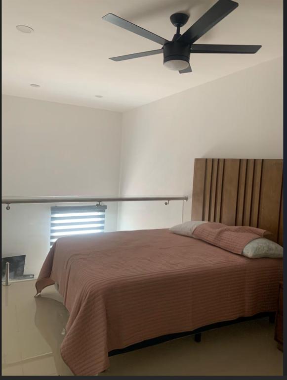 a bedroom with a bed with a ceiling fan at Complejo Las Flores in Durango