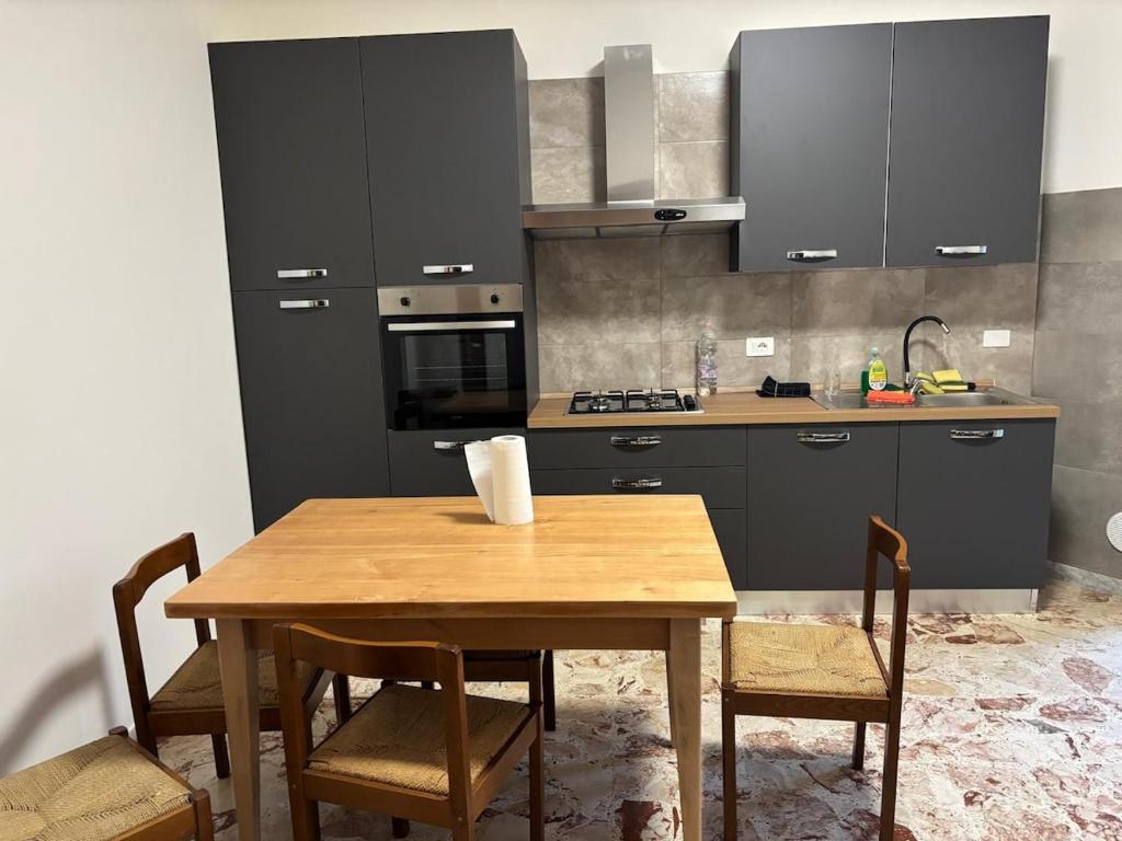 a kitchen with a wooden table with chairs and a sink at Dayana House in Gallipoli