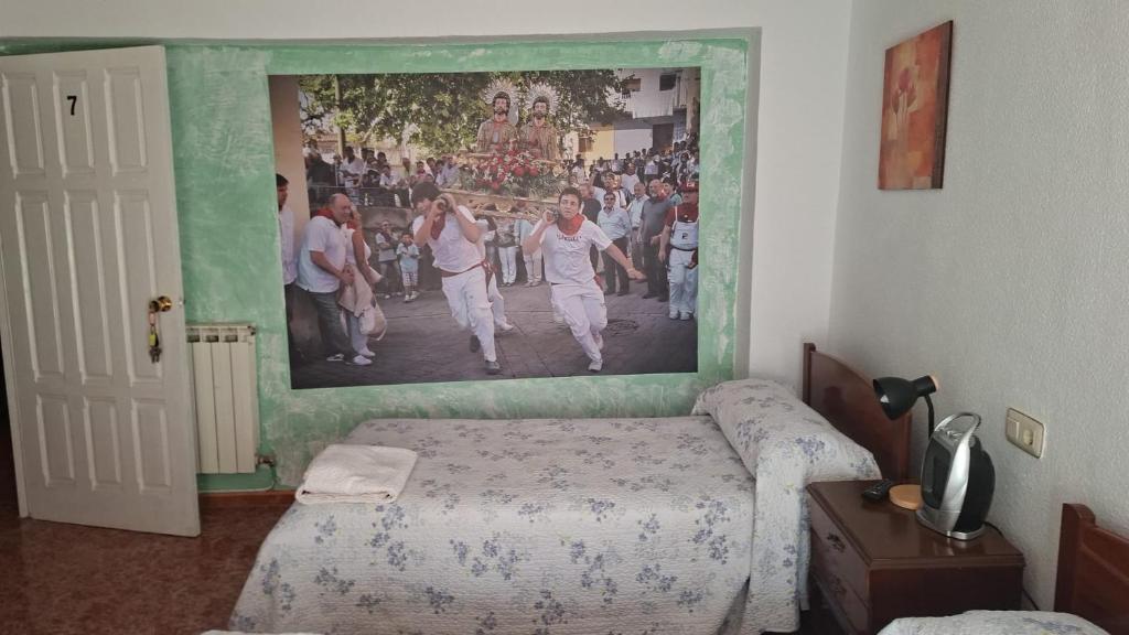 a bedroom with a painting on the wall at Pensiòn ISASA in Arnedo