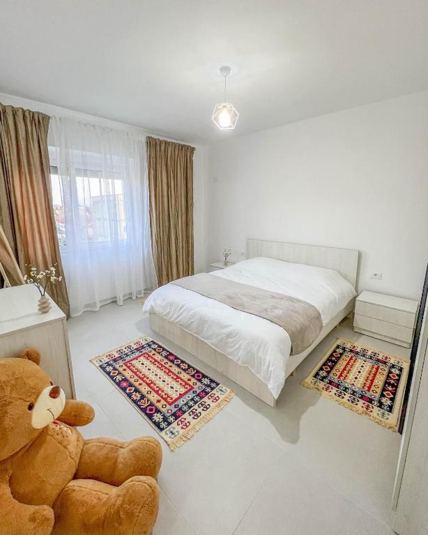 a bedroom with a large bed and a teddy bear at Modern Air Conditioned 2BR in Heart of Shkodër in Shkodër