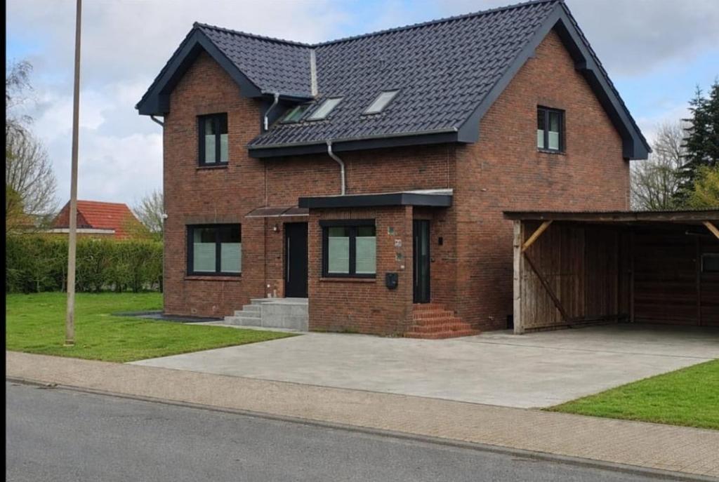 a brick house with a black roof and a garage at Gästehof Bützfleth in Stade