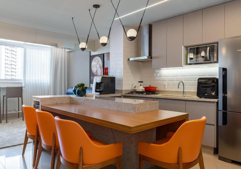 a kitchen with a table and orange chairs in it at Metropolitan Sidney in Goiânia