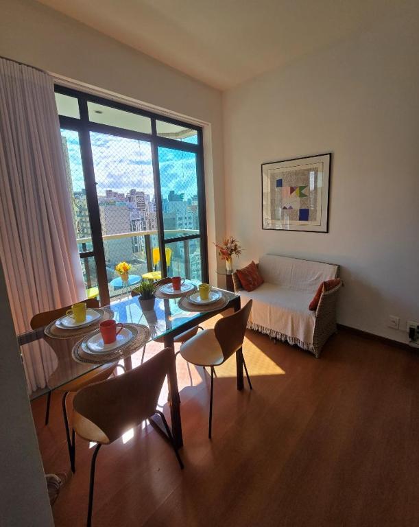 a living room with a table and chairs and a couch at Volpi Residence Savassi - VIP - Sinta-se em casa in Belo Horizonte