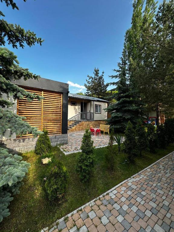 a backyard of a house with a brick driveway at Bellissimo Garden Villa in Tsaghkadzor