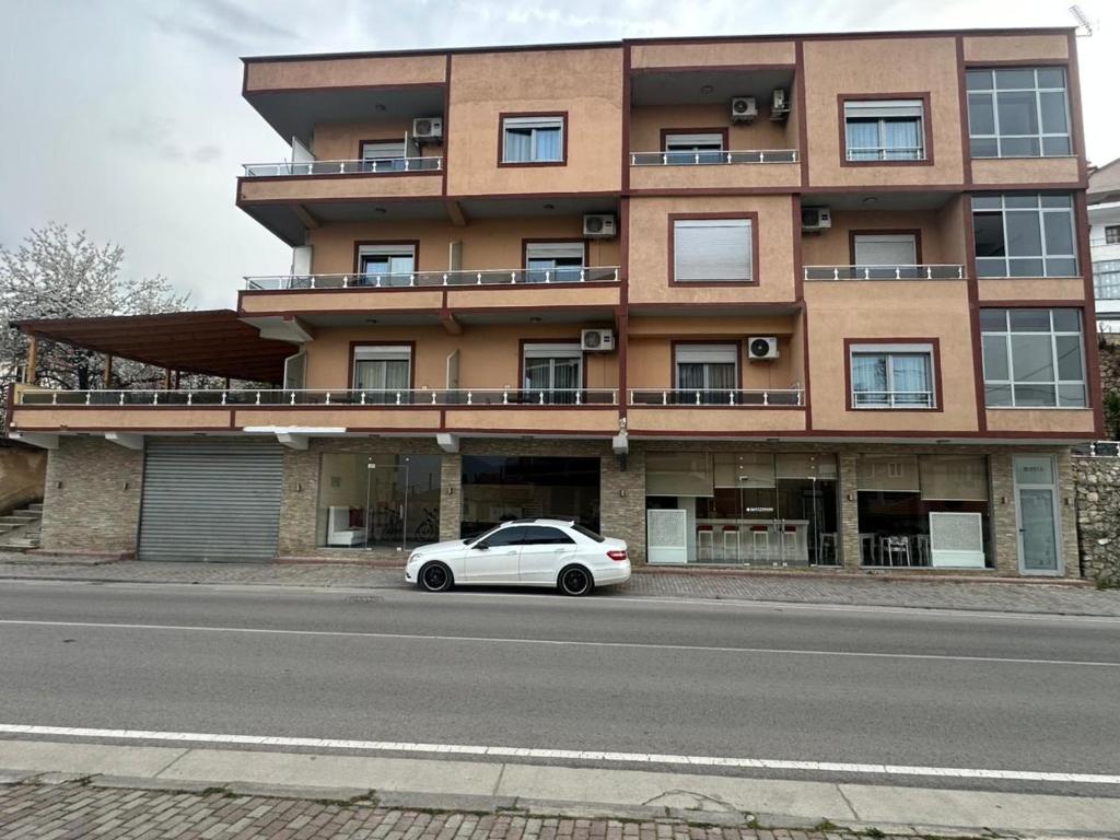 a white car parked in front of a building at Hotel Yjet in Pogradec