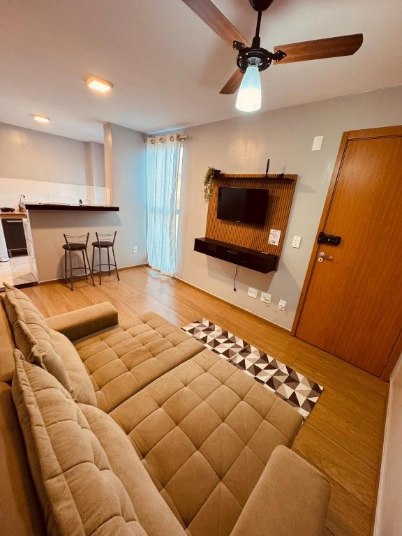 a large couch in a living room with a ceiling fan at Apt 404 BL 6 entrada de londrina in Cambé