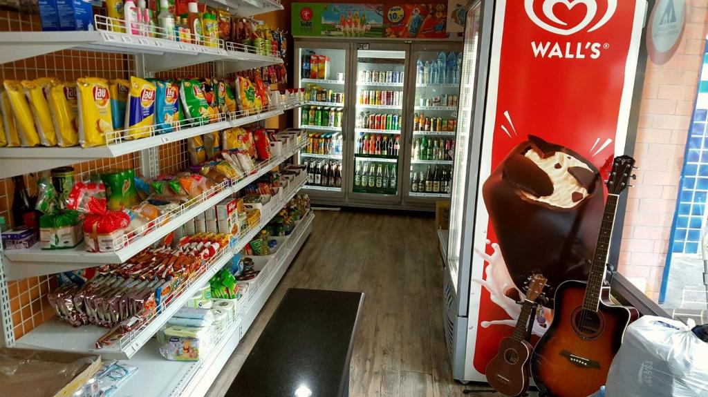 a store with a refrigerator with a guitar in it at iSanook Hostel in Bangkok