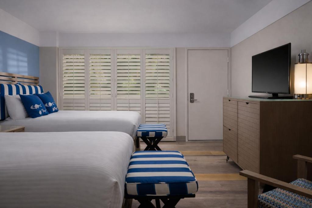 a hotel room with two beds and a television at Inn at Morro Bay in Morro Bay