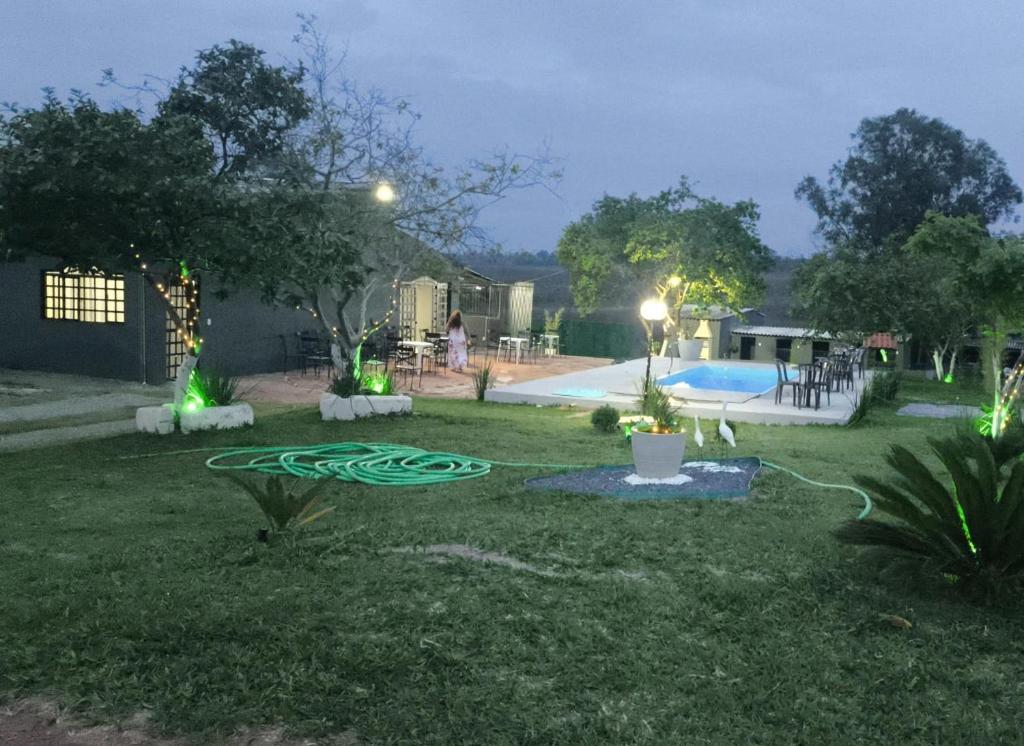 a backyard at night with a pool and a green hose at Espaço Vip in Brasília
