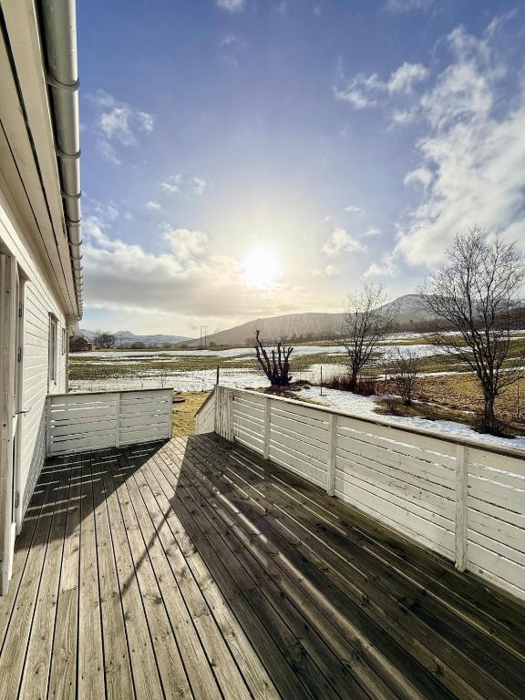 a porch of a house with a wooden deck at Cozy House by the Lake in Vestvågøya