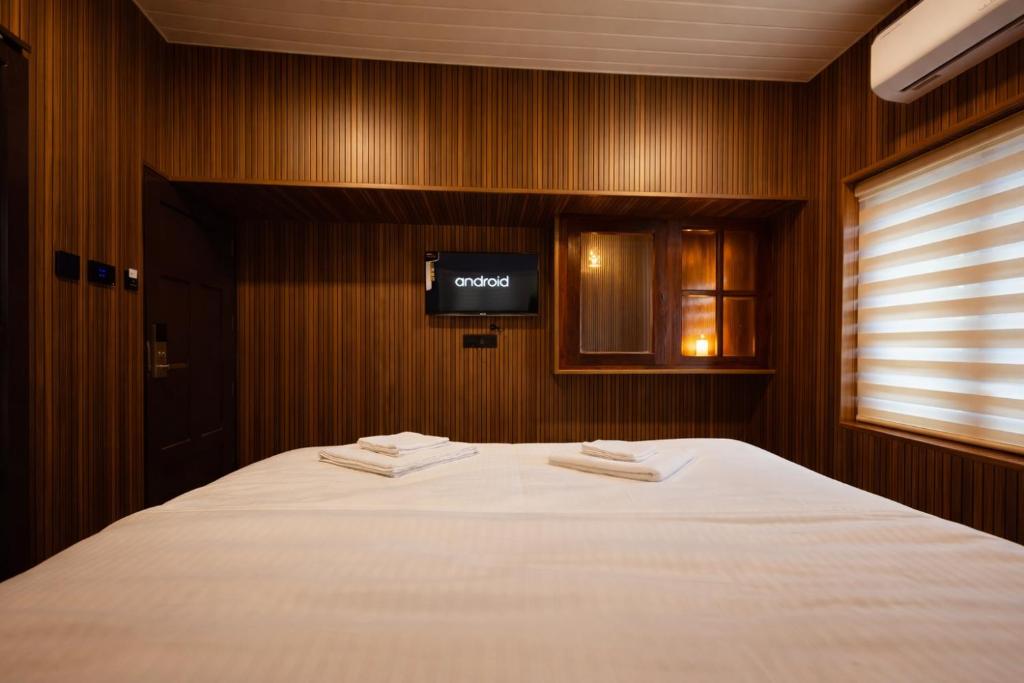 a bedroom with a bed with a tv on the wall at The VARKALA HAVEN 105 in Varkala