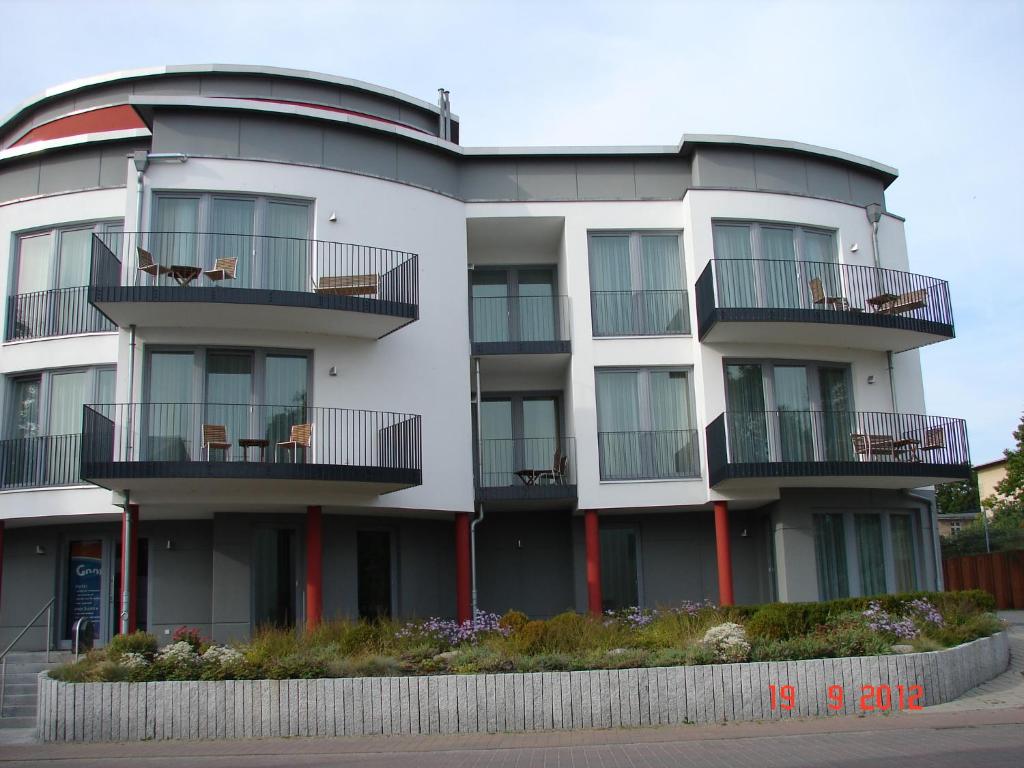 ein weißes Gebäude mit einem Hund auf dem Balkon in der Unterkunft Hotel Goor und Apartmenthaus in Lauterbach