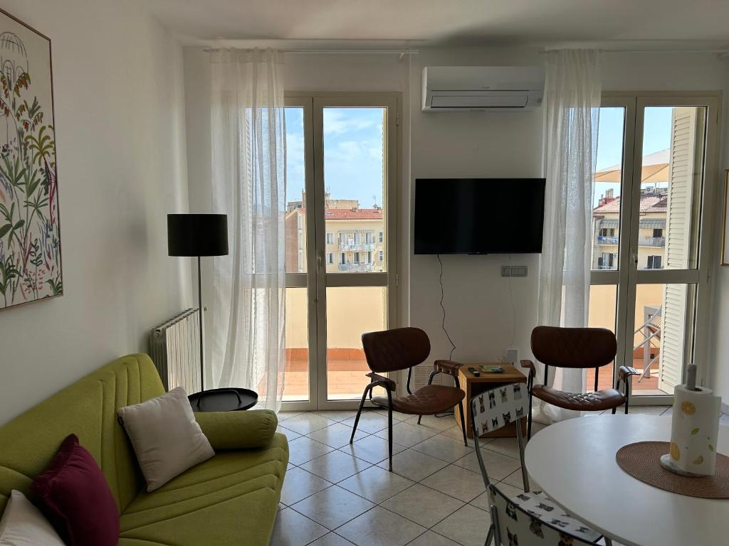 a living room with a green couch and a table at A & M Appartamento con garage in Livorno