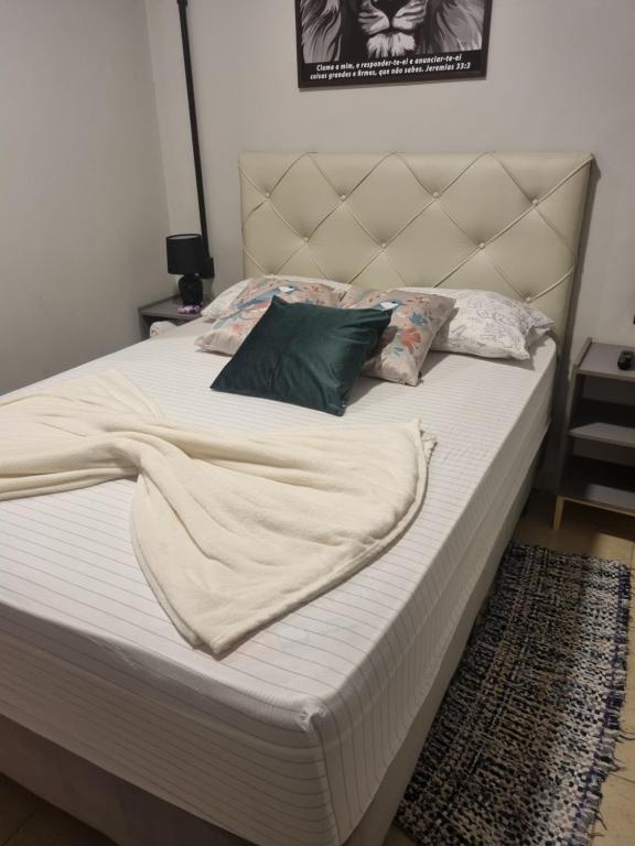 a bed with white sheets and pillows on it at Hotel Giselle Boutique in Boa Vista