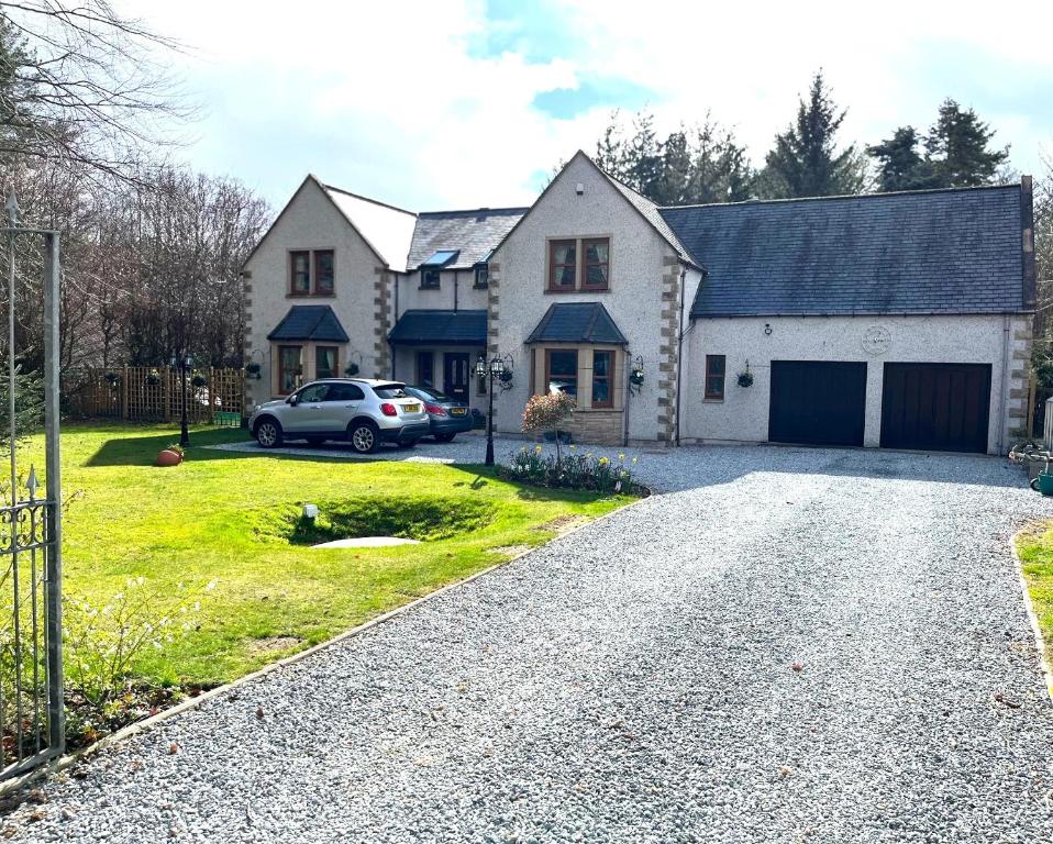 a house with a car parked in the driveway at Copper Beeches in Elgin
