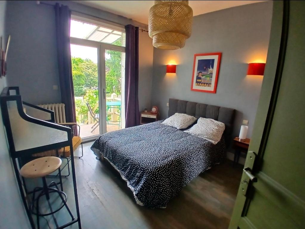a bedroom with a bed and a large window at Cyrus House - maison complète 90m2 in Le Mans