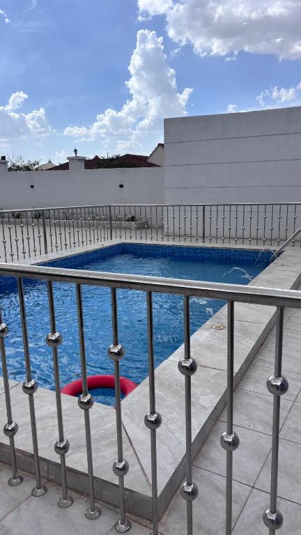 a swimming pool on a building with a fence at شاليه الجاكرندا 8 in Taif