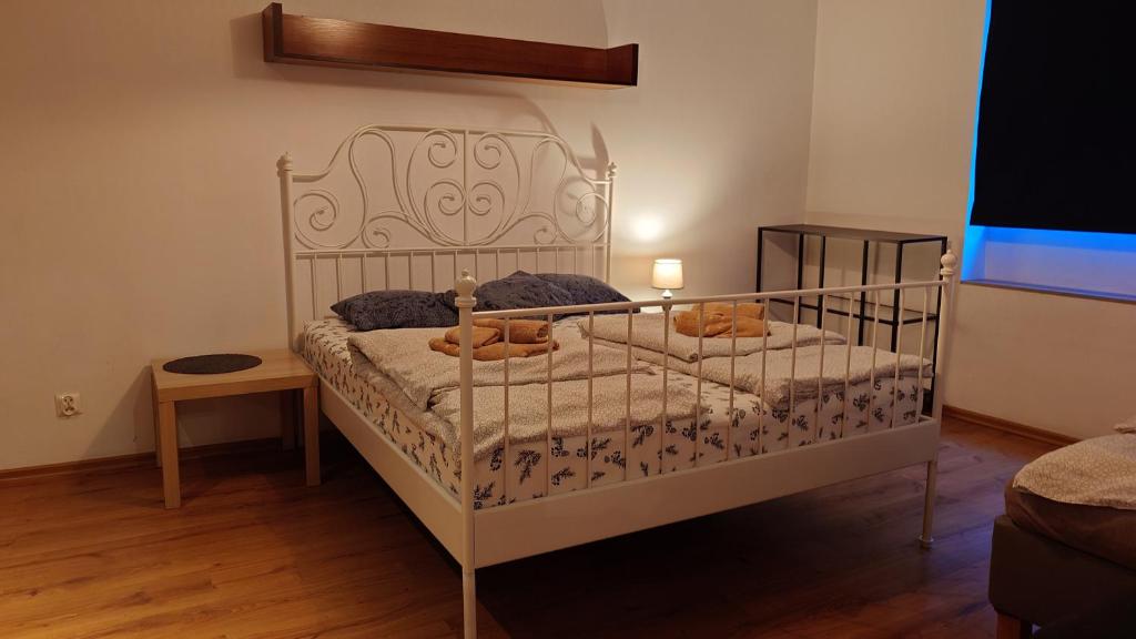 a bedroom with a white bed with a wooden floor at Apartamenty nad Stonehenge in Dąbrowa Górnicza