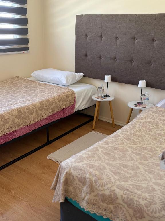 a room with two beds and two tables with lamps at Casa de Melinka in Mejillones