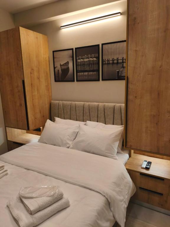a bedroom with a large white bed with two towels on it at Lounetta Apartments 1 in Missolonghi