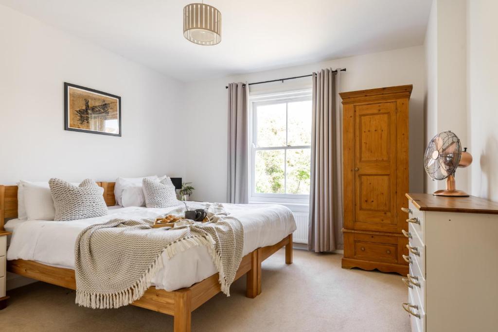 a bedroom with a bed and a window at Talbot Cottage in Lymington