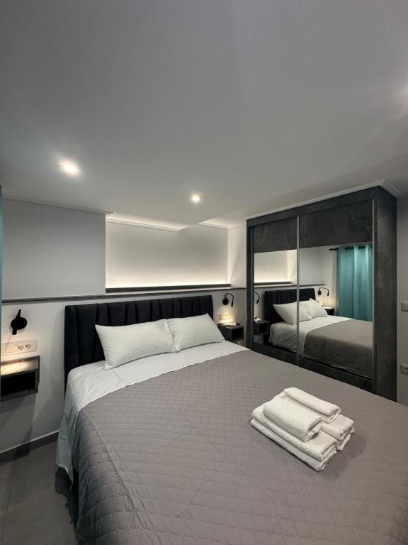 a bedroom with a large bed with towels on it at Golden Ecco Suites in Nafpaktos