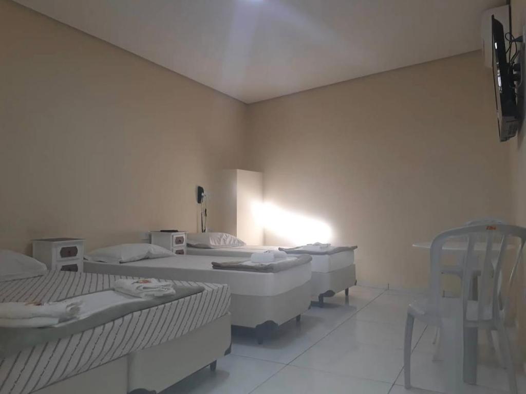 a white room with four beds in it at Hotel Interlagos Plaza in São Paulo