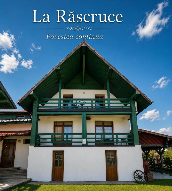 a house with a green and white building at La Răscruce in Gărâna