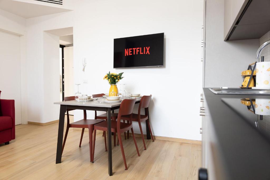 a kitchen and dining room with a table and chairs at Moderno Bilocale Con Parcheggio Privato in Piacenza
