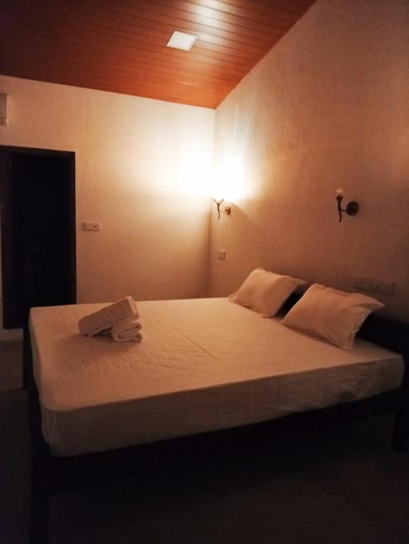 a bedroom with a bed with a light on the wall at Cozy Vibe Villa in Arugam Bay