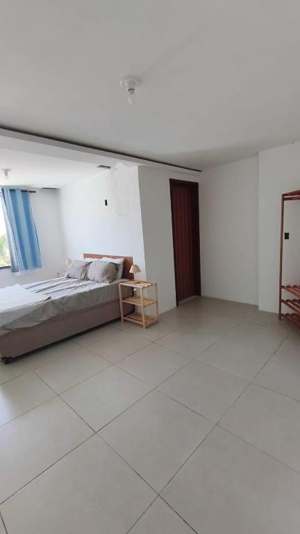 a large white room with a bed and a window at Quintal da Gra in Araruama
