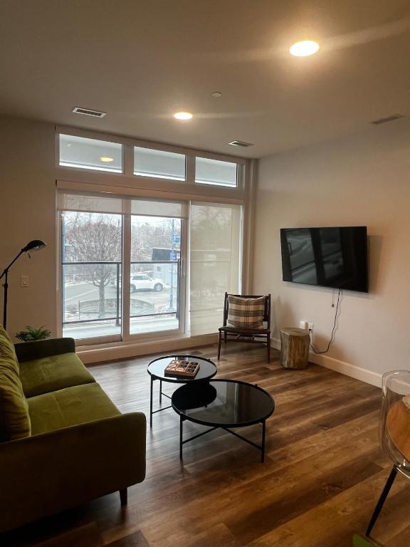 a living room with a couch and a table and a tv at New The Carlyle 209 Beachside Condo in Grand Bend in Grand Bend