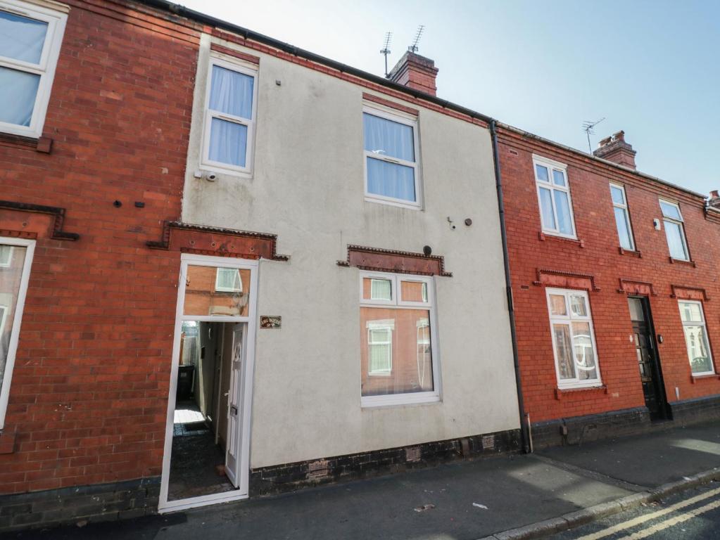 a brick building with an open door on a street at JMG House in West Bromwich