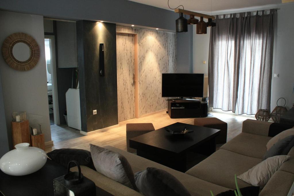 a living room with a couch and a tv at Despina's apts in Kalamariá
