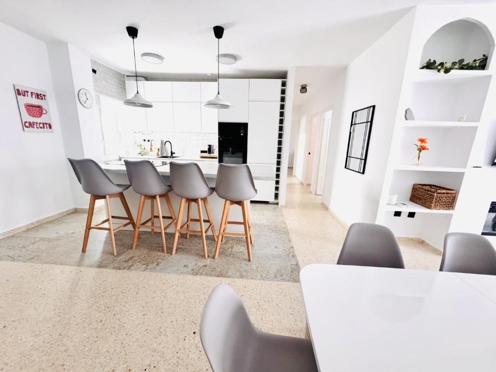 a kitchen with white walls and a table and chairs at Sala 8 Gran Cinema in Sanlúcar de Barrameda
