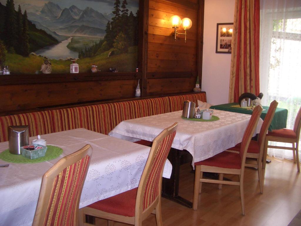 a dining room with a table and chairs and a painting at Haus Grützner in Dorfgastein