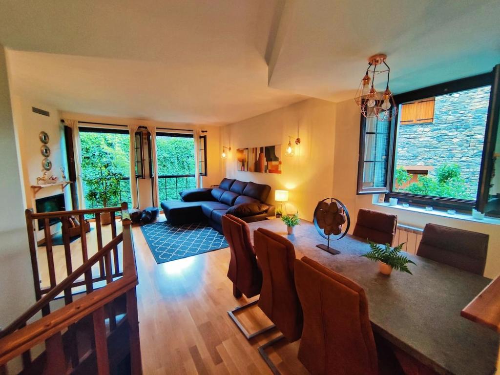 a living room with a couch and a table at Acojedor dúplex en la naturaleza in Valencia de Aneu