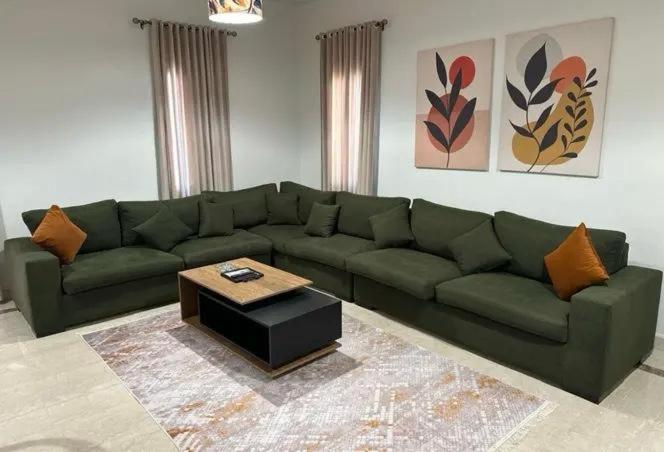 a living room with a green couch and a coffee table at parkoo jajaaa in Dammam